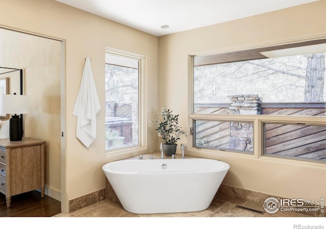bathroom with a freestanding bath and baseboards