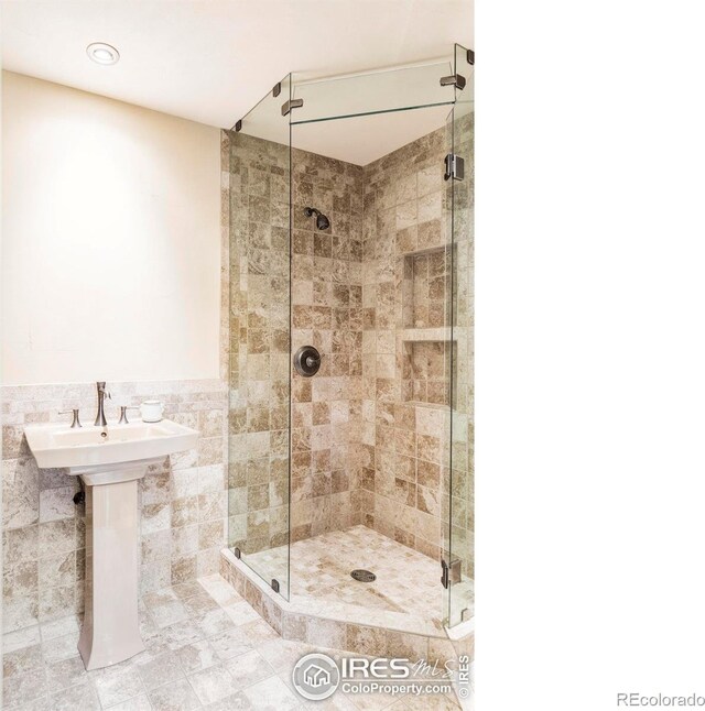 full bath with a stall shower and tile walls