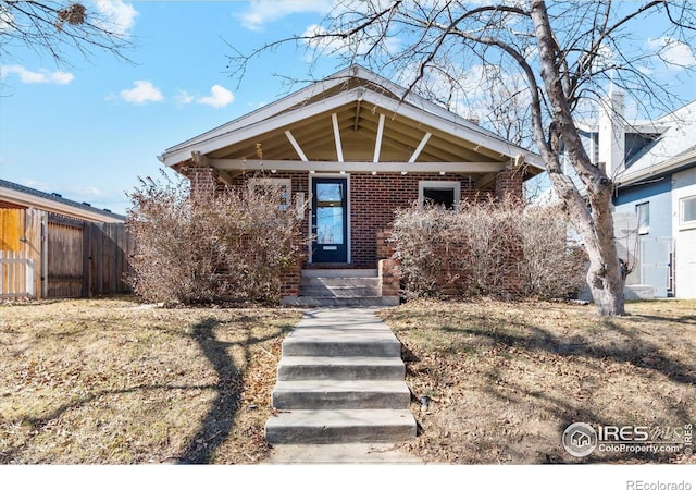 view of front of house with fence and brick siding