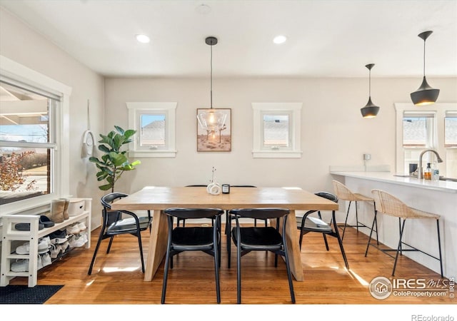 dining area with healthy amount of natural light, light wood finished floors, and recessed lighting