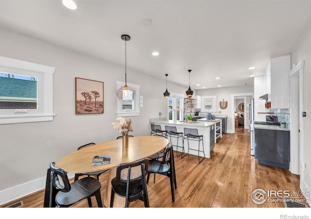 dining space featuring light wood finished floors, recessed lighting, and baseboards