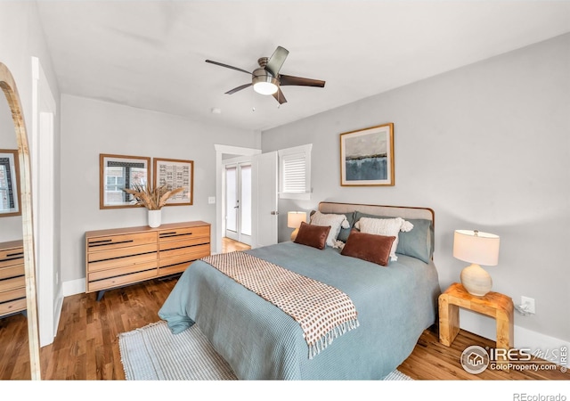 bedroom with wood finished floors, baseboards, and ceiling fan