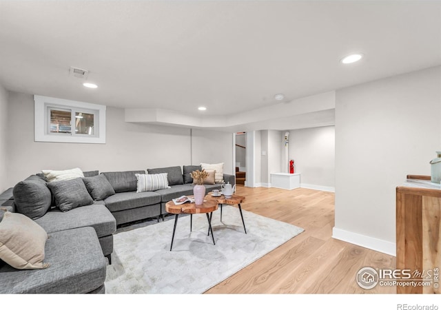 living room featuring light wood-style floors, recessed lighting, and baseboards
