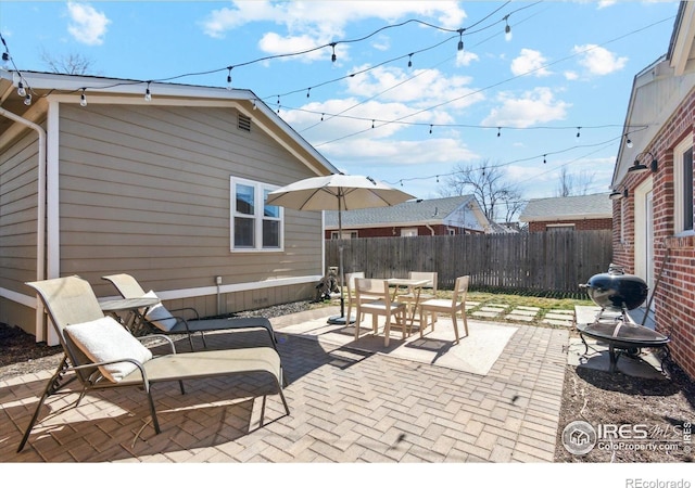 view of patio with outdoor dining space and fence