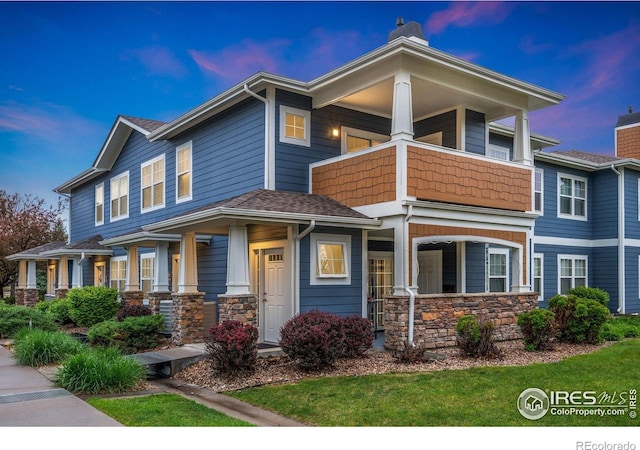 2502 Owens Ave Unit 201, Fort Collins, CO 80528 - view of front facade with a porch, a balcony, stone siding, and a chimney