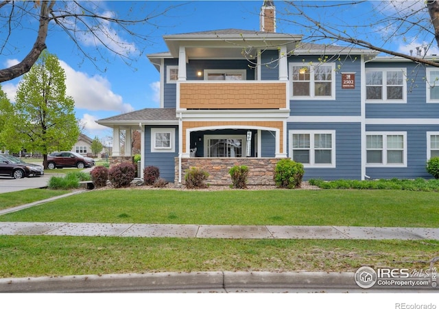 2502 Owens Ave Unit 201, Fort Collins, CO 80528 - view of front of house featuring stone siding, a chimney, a front yard, and a shingled roof