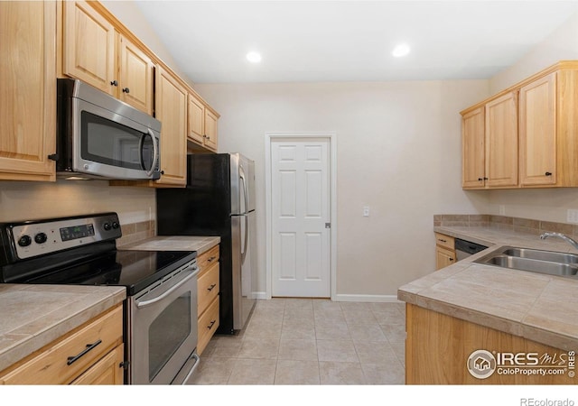 2502 Owens Ave Unit 201, Fort Collins, CO 80528 - kitchen with appliances with stainless steel finishes, light brown cabinets, a sink, light tile patterned floors, and recessed lighting