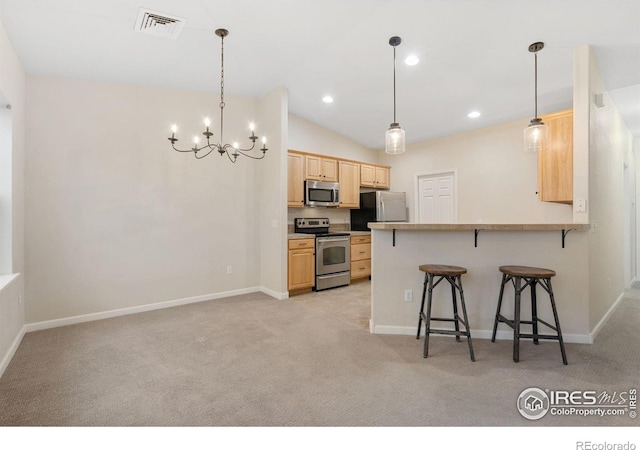 2502 Owens Ave Unit 201, Fort Collins, CO 80528 - kitchen with appliances with stainless steel finishes, light brown cabinetry, light carpet, a breakfast bar area, and a chandelier