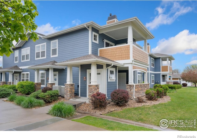 2502 Owens Ave Unit 201, Fort Collins, CO 80528 - view of front of property featuring a chimney, a front lawn, stone siding, and a balcony