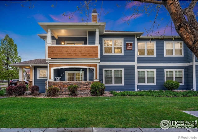 2502 Owens Ave Unit 201, Fort Collins, CO 80528 - view of front facade with a balcony, a chimney, and a front yard