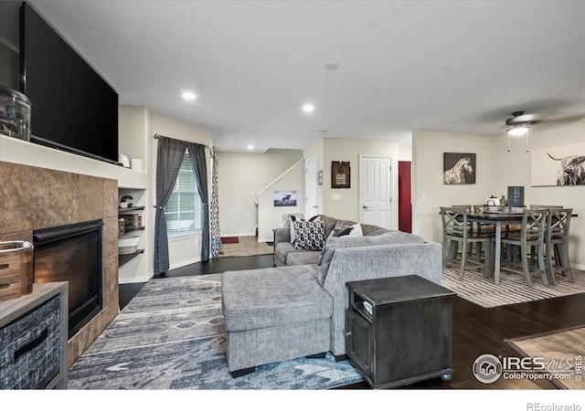 living room featuring wood finished floors, a fireplace, a ceiling fan, and recessed lighting