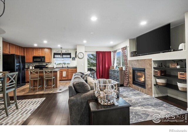 living room featuring dark wood finished floors, a fireplace, and recessed lighting
