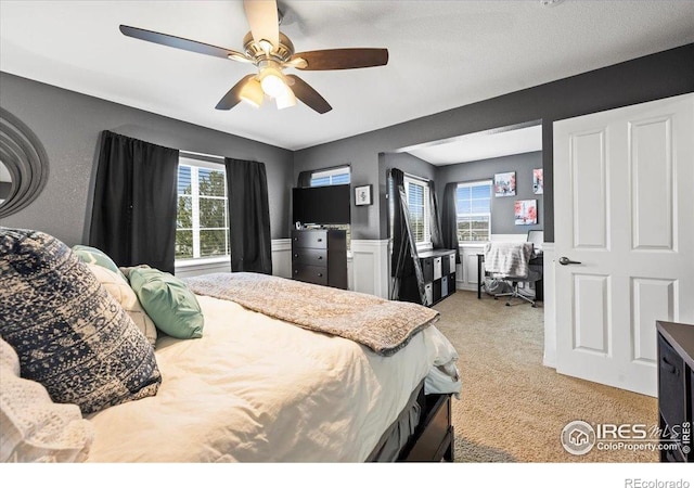 bedroom with light colored carpet, a desk, and ceiling fan