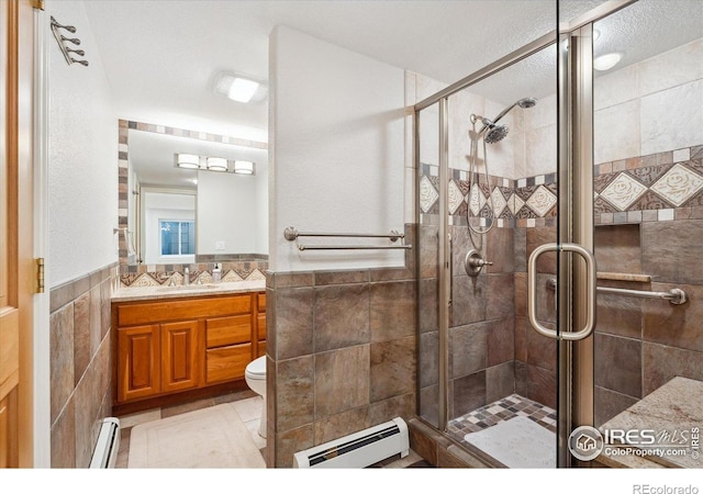 4059 Nevis St, Boulder, CO 80301 - bathroom with a baseboard radiator, tile walls, vanity, a shower stall, and wainscoting