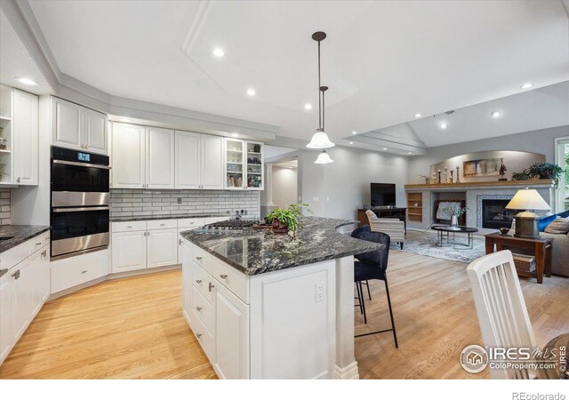 4059 Nevis St, Boulder, CO 80301 - kitchen featuring appliances with stainless steel finishes, light wood-style floors, a kitchen island, tasteful backsplash, and recessed lighting