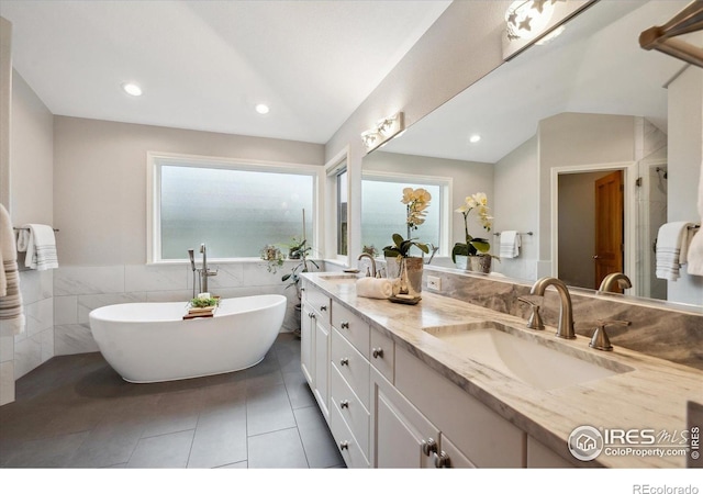 4059 Nevis St, Boulder, CO 80301 - full bath with double vanity, tile patterned floors, a soaking tub, tile walls, and recessed lighting