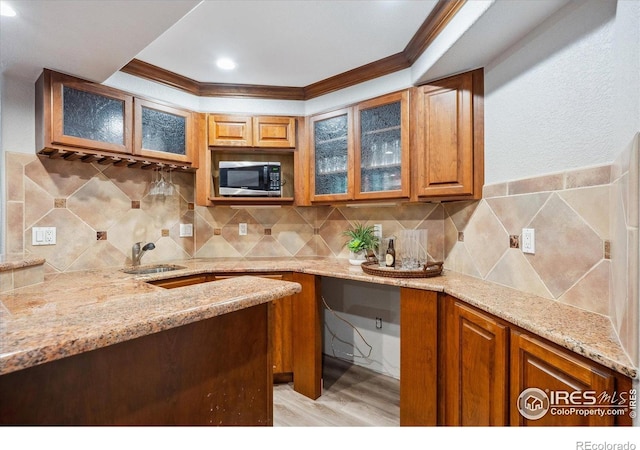 4059 Nevis St, Boulder, CO 80301 - kitchen featuring stainless steel microwave, light stone countertops, ornamental molding, light wood-style flooring, and brown cabinetry