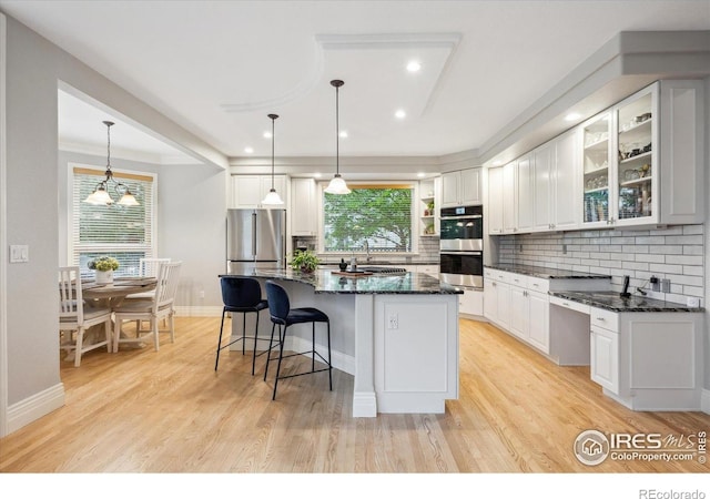 4059 Nevis St, Boulder, CO 80301 - kitchen with appliances with stainless steel finishes, white cabinetry, tasteful backsplash, a center island, and recessed lighting