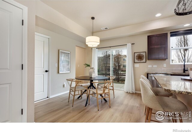 dining area featuring light wood-style floors, baseboards, and recessed lighting