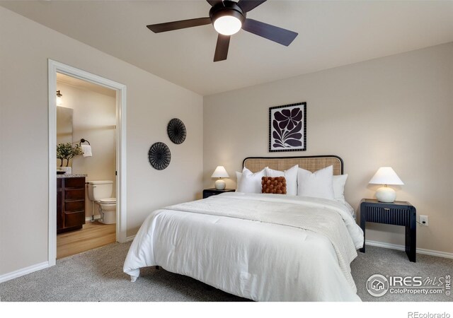 carpeted bedroom with connected bathroom, baseboards, and a ceiling fan