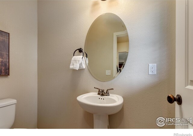 half bath with toilet and a sink