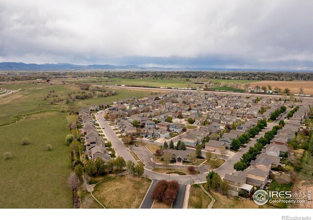 aerial view of property's location featuring nearby suburban area and a mountain backdrop