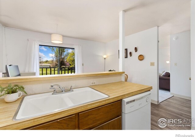 705 E Drake Rd Unit 22, Fort Collins, CO 80525 - kitchen featuring dishwasher, brown cabinets, a sink, light countertops, and wood finished floors