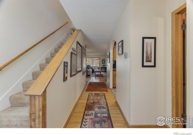 620 Macgregor Ave Unit 2, Estes Park, CO 80517 - hall with arched walkways, light wood finished floors, a textured ceiling, and stairs