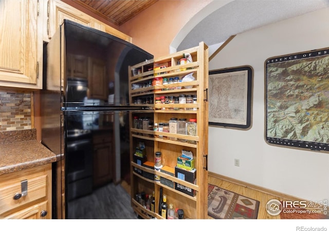 620 Macgregor Ave Unit 2, Estes Park, CO 80517 - kitchen featuring backsplash, dark wood-type flooring, arched walkways, and freestanding refrigerator