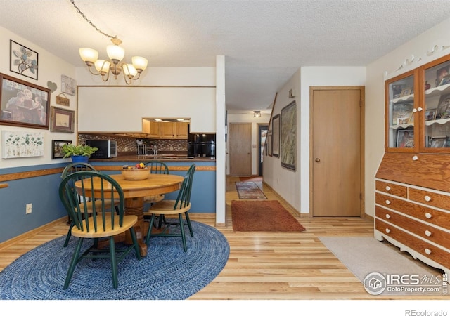 620 Macgregor Ave Unit 2, Estes Park, CO 80517 - dining area featuring a textured ceiling, a chandelier, and light wood-style flooring