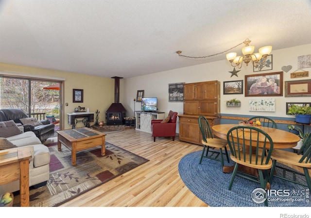 620 Macgregor Ave Unit 2, Estes Park, CO 80517 - dining area featuring a wood stove, a chandelier, light wood finished floors, and a textured ceiling