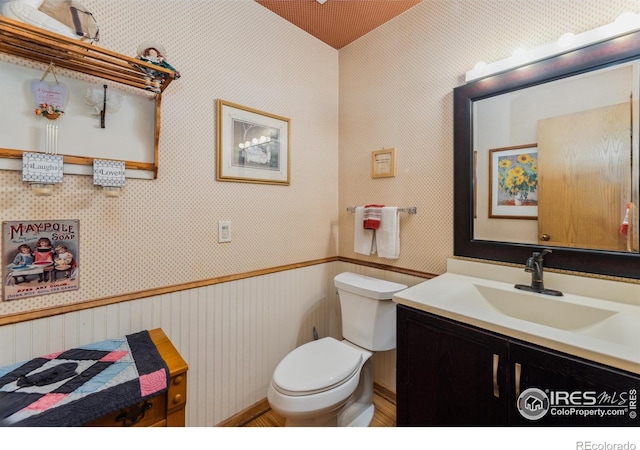620 Macgregor Ave Unit 2, Estes Park, CO 80517 - bathroom featuring toilet, vanity, wallpapered walls, and wood finished floors