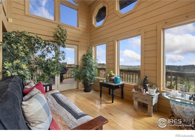 331 Laplata Dr, Livermore, CO 80536 - sunroom / solarium with wooden walls, wood finished floors, a high ceiling, and a deck