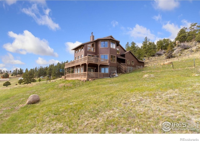331 Laplata Dr, Livermore, CO 80536 - rear view of house with a chimney, a yard, a wooden deck, and stairs