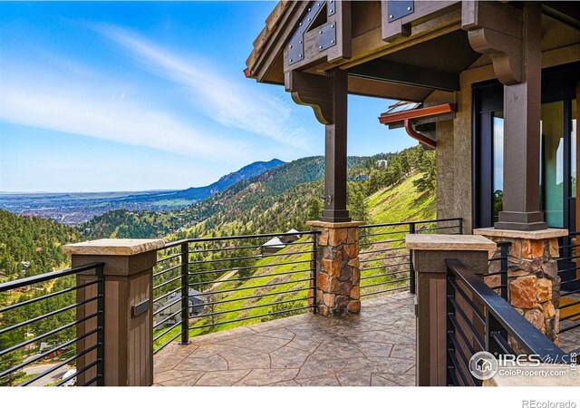 view of patio with a mountain view and a balcony
