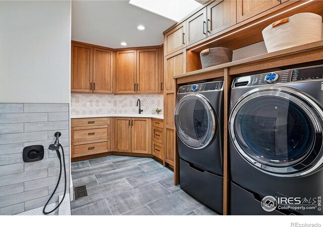washroom with washer and clothes dryer, cabinet space, and recessed lighting