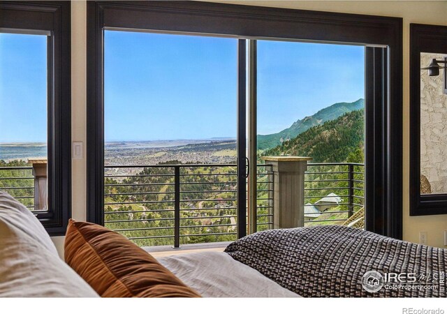 bedroom featuring multiple windows and a water and mountain view