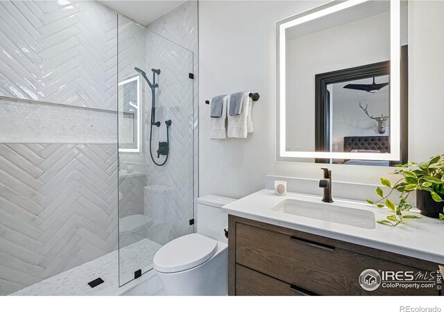 bathroom featuring a tile shower, toilet, and vanity
