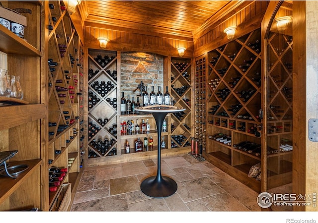 wine room with wooden ceiling and stone tile floors
