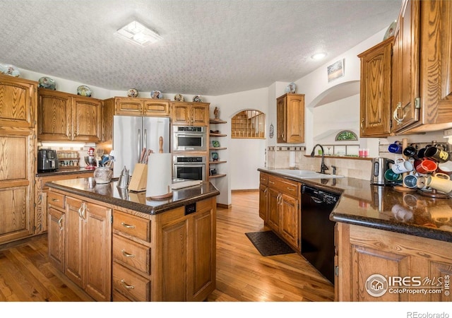 7309 Didrickson Ct, Fort Collins, CO 80528 - kitchen with appliances with stainless steel finishes, a sink, open shelves, arched walkways, and wood finished floors
