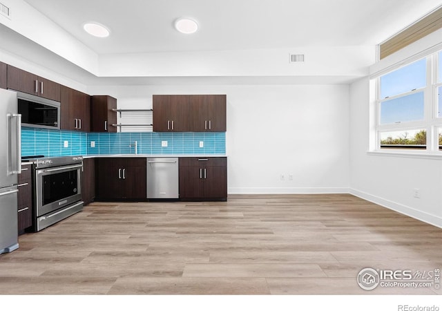 kitchen featuring appliances with stainless steel finishes, open shelves, dark brown cabinets, and tasteful backsplash