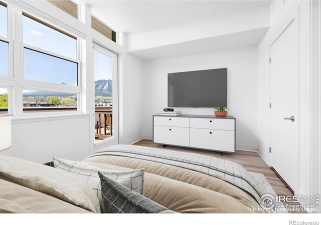 bedroom featuring light wood finished floors and baseboards