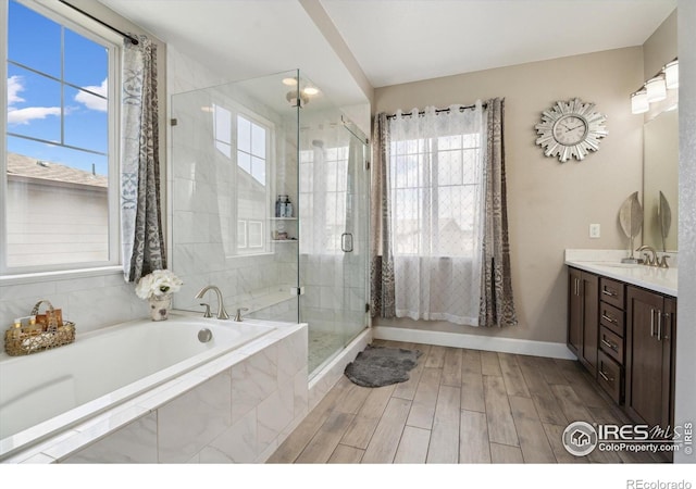 25190 E Nova Pl, Aurora, CO 80016 - full bathroom featuring a bath, a stall shower, vanity, baseboards, and wood finished floors