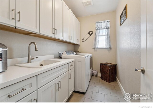 25190 E Nova Pl, Aurora, CO 80016 - laundry area with cabinet space, washer and clothes dryer, baseboards, and light tile patterned flooring