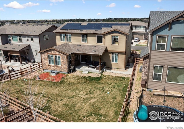 25190 E Nova Pl, Aurora, CO 80016 - rear view of house featuring a residential view, roof mounted solar panels, a patio, and a shingled roof