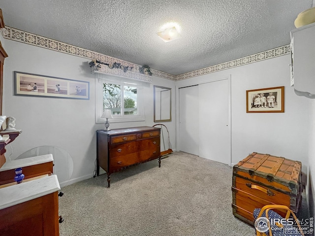 1145 S Bowman Ave, Holyoke, CO 80734 - bedroom featuring a textured ceiling, a closet, and light carpet