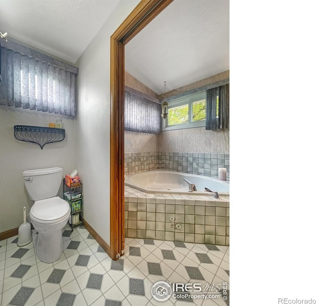 1145 S Bowman Ave, Holyoke, CO 80734 - bathroom featuring toilet, a garden tub, tile patterned floors, baseboards, and lofted ceiling