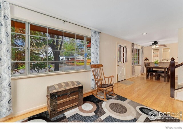 living area featuring wood finished floors, ceiling fan, baseboards, and recessed lighting