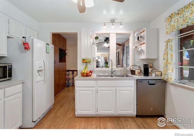 kitchen featuring stainless steel appliances, a ceiling fan, a sink, and light wood finished floors