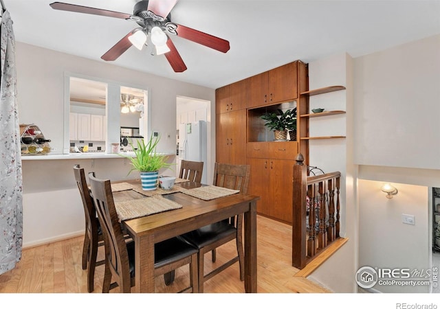 dining room with ceiling fan and light wood-style floors